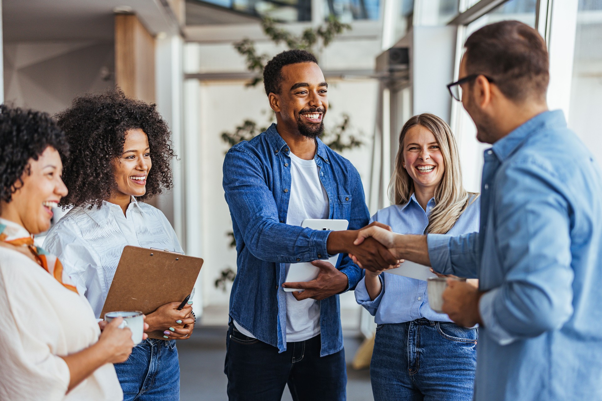 Diverse Team Meeting with Smiling Colleagues and Handshake
